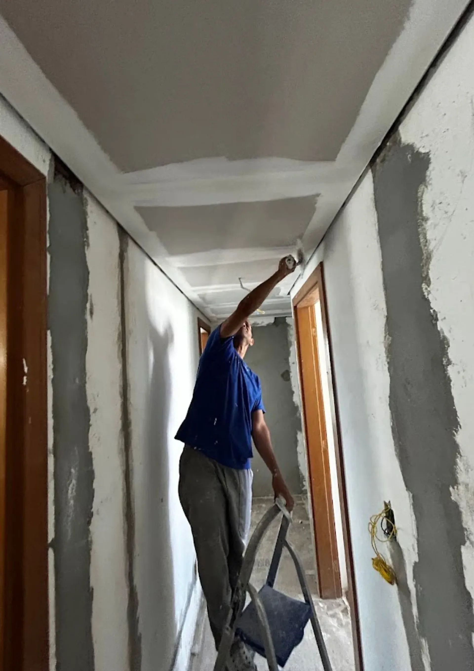 Profissional da equipe da Pilares aplicando acabamento nas paredes de uma obra